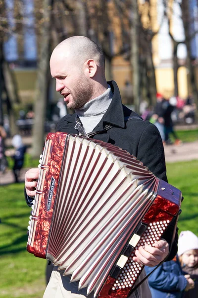 街头音乐家在圣彼得堡的城市居民面前弹奏手风琴 — 图库照片