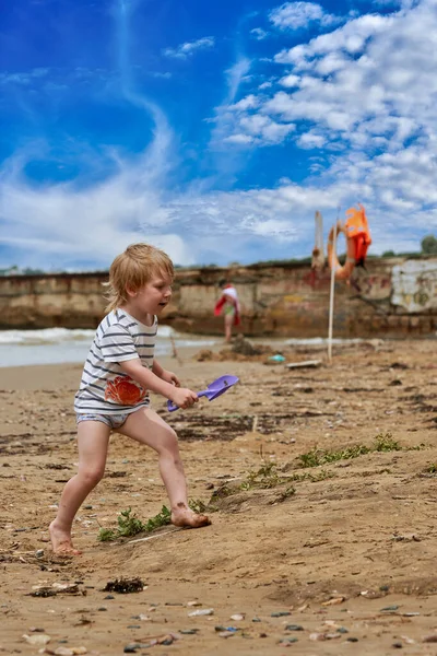 小さな男の子が海岸沿いの砂浜を走っている 海に眠る子供たち — ストック写真