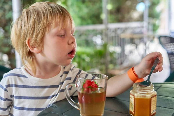 Bambino Sta Bevendo Con Miele Sulla Veranda Estiva Ragazzino Mangiare — Foto Stock