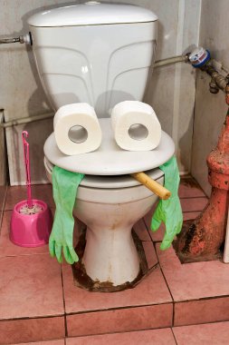 Tuvalet kapağındaki iki rulo tuvalet kağıdı insan kafasını andırıyor.