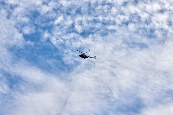 Repülő helikopter hátán a kék ég lucfenyő felhők — Stock Fotó