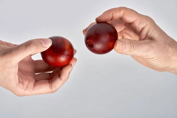 Dos manos sostienen los huevos e intentan romperse el uno al otro huevo —  Fotos de Stock