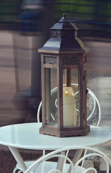 Lanterna com uma vela em uma mesa em um café . — Fotografia de Stock