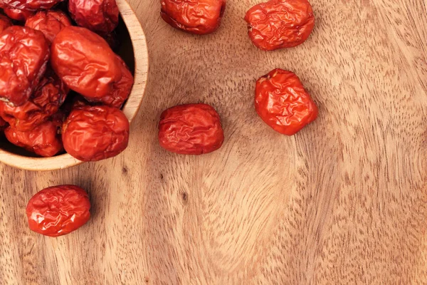 Close up of red jujube fruit on wooden background with copy space.