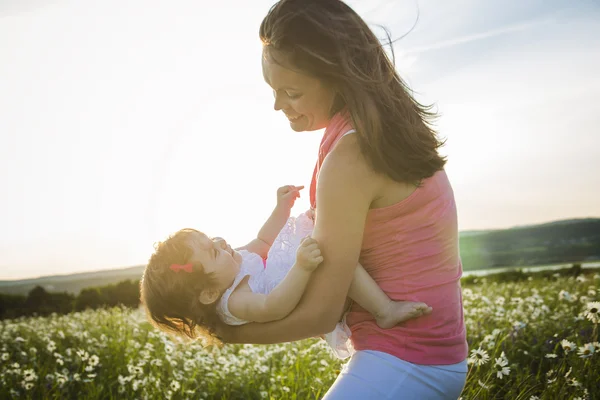 Glückliche freudige Mutter mit Tochter Gänseblümchenfeld — Stockfoto