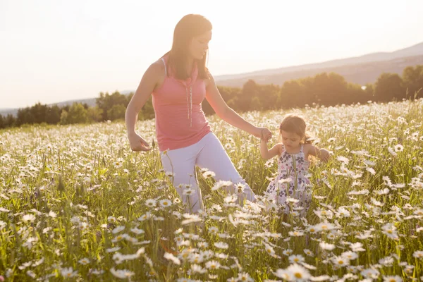 Glad glad mamma med dotter daisy fält — Stockfoto