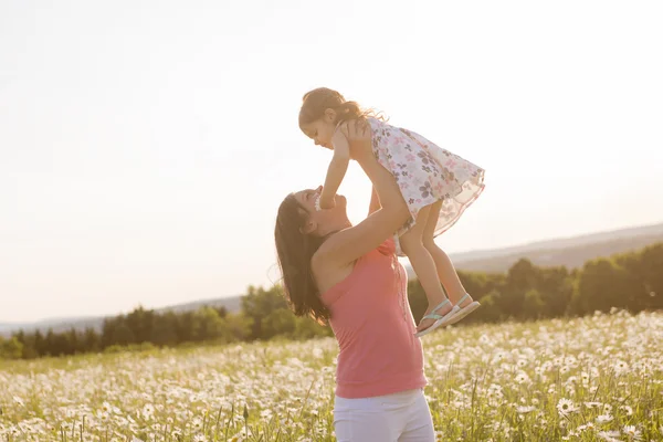 Glückliche freudige Mutter mit Tochter Gänseblümchenfeld — Stockfoto