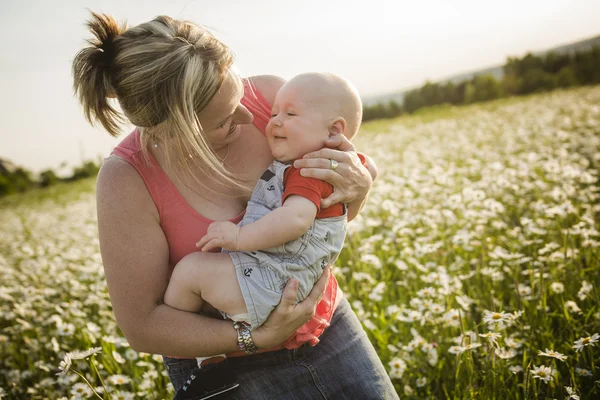 Happy joyful mother with son daisy field — Stock Photo, Image