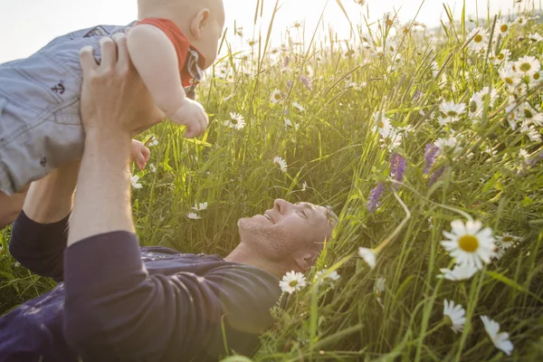 Happy joyful father with baby daisy field — Stock Photo, Image