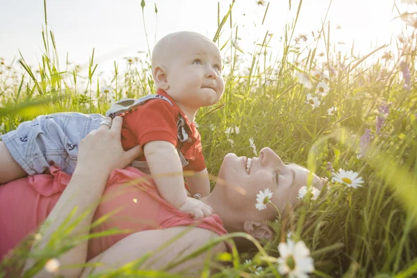 Happy joyful mother with son daisy field — Stock Photo, Image