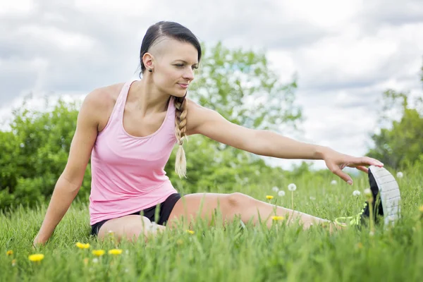 Junge Athletin trainiert und dehnt sich in einem Park — Stockfoto