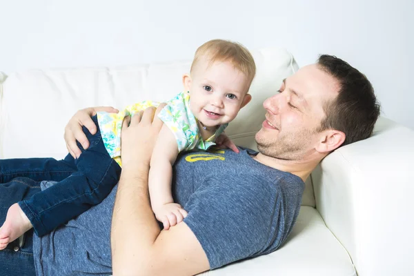 Padre con el bebé en el sofá tomando un buen tiempo — Foto de Stock