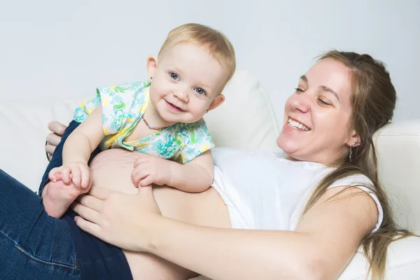 Mãe com bebê no sofá tomando bom tempo — Fotografia de Stock