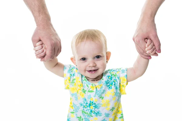 Baby taking first steps with mother father help on white background — Stock Photo, Image