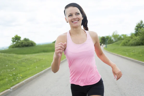 Mujer deportiva corriendo al aire libre en el parque —  Fotos de Stock