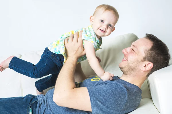 良い時間を割いてソファの上に赤ちゃんを持つ父 — ストック写真