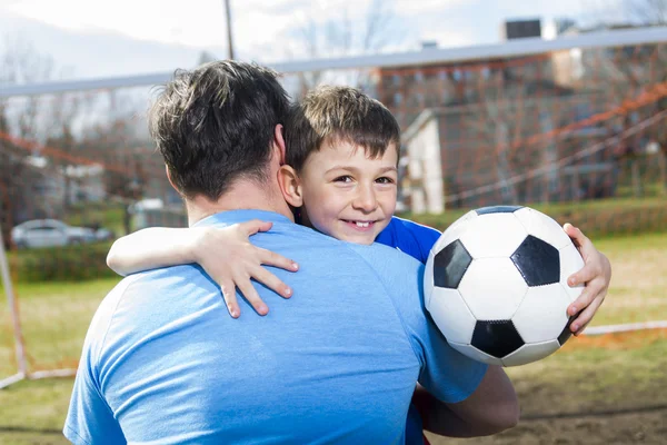 Uomo con bambino che gioca a calcio in campo — Foto Stock