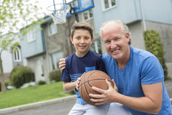 Beeld van jonge man en zijn zoon spelen basketbal — Stockfoto