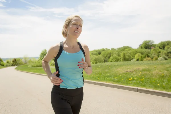 Mature woman running outdoors in the park — Stock Photo, Image