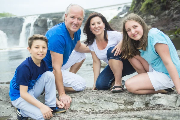 Vrolijke familie in waterval gebied portret — Stockfoto