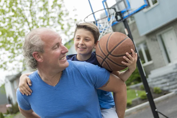 Beeld van jonge man en zijn zoon spelen basketbal — Stockfoto