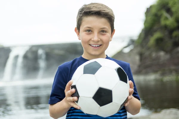 Dos jóvenes al aire libre con pelota de fútbol sonriendo — Foto de Stock