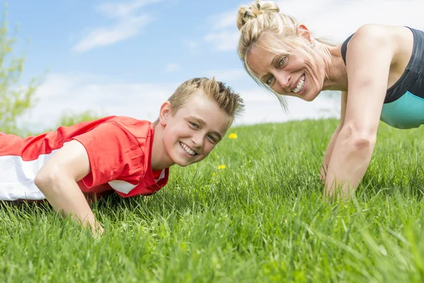 Szczęśliwy syn i matka robi ćwiczenia w parku lato — Zdjęcie stockowe