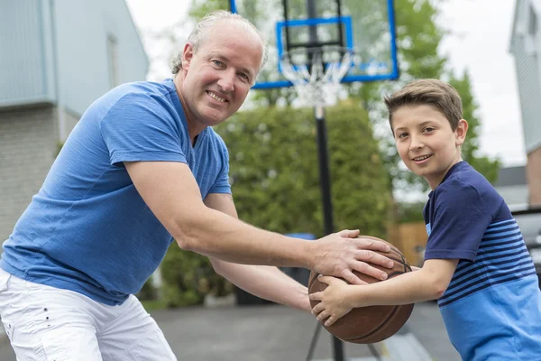 Beeld van jonge man en zijn zoon spelen basketbal — Stockfoto