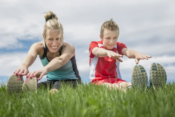 Feliz filho e mãe estão fazendo exercícios no parque de verão — Fotografia de Stock