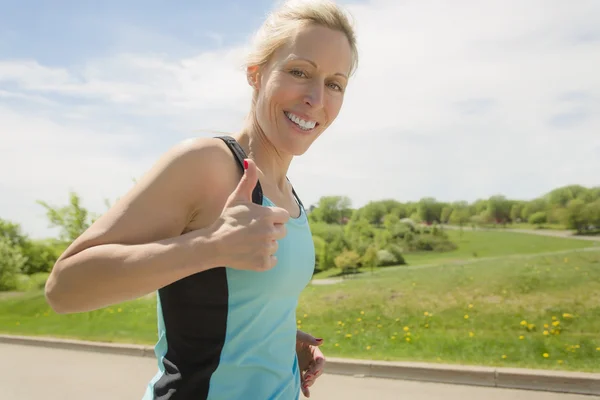 Mature woman running outdoors in the park — Stock Photo, Image