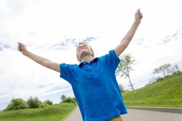 Happy teenager with hand high outside in sunny day — Stock Photo, Image