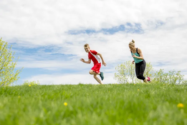 Familj, mor och son är igång eller jogging för idrott utomhus — Stockfoto