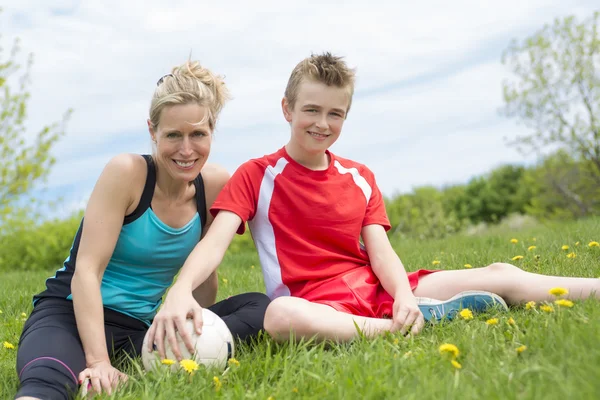 Joyeux jeune famille jouant au football en plein air un jour d'été — Photo