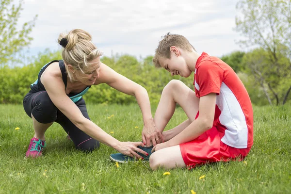 Athletic chłopiec trzyma jej bolesnych kontuzji kostki — Zdjęcie stockowe