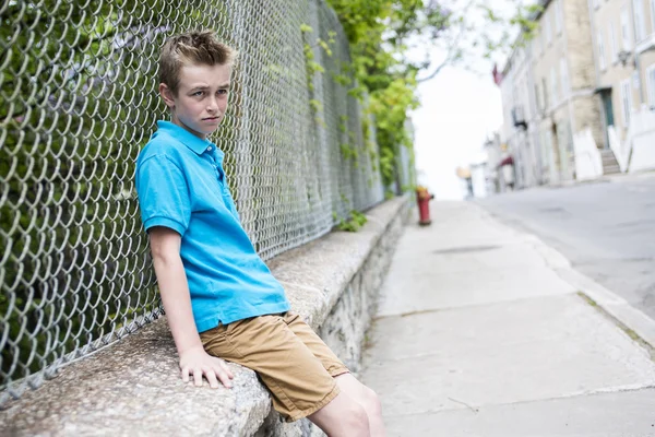 Giovane ragazzo adolescente guardando fuori da una recinzione — Foto Stock