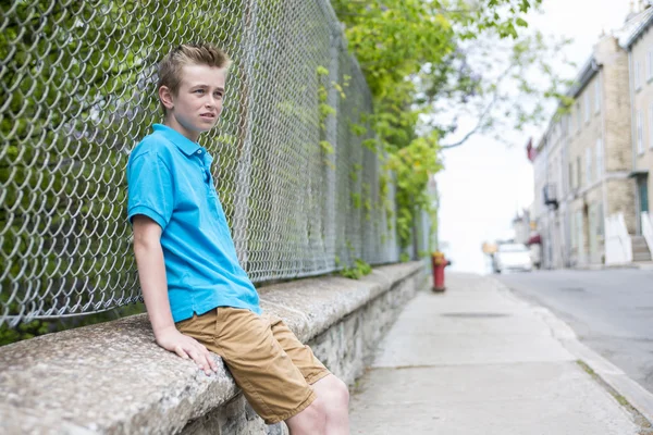 Мальчик-подросток, выглядывающий из забора — стоковое фото