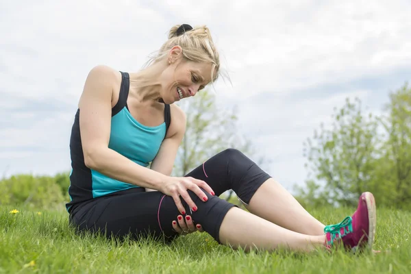 Femme coureuse tenir son genou blessé sportif — Photo