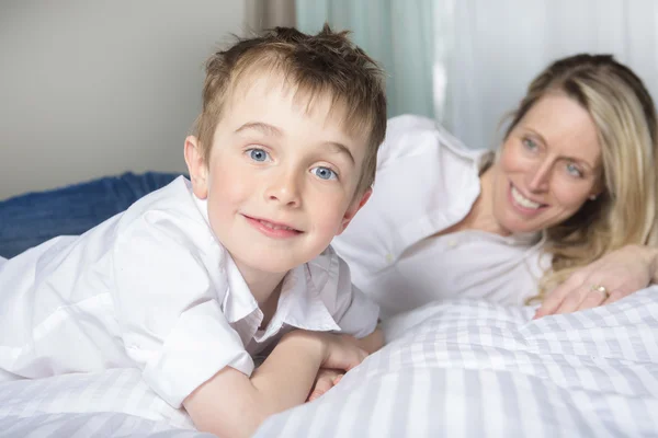 Madre e hijo relajándose juntos en la cama — Foto de Stock