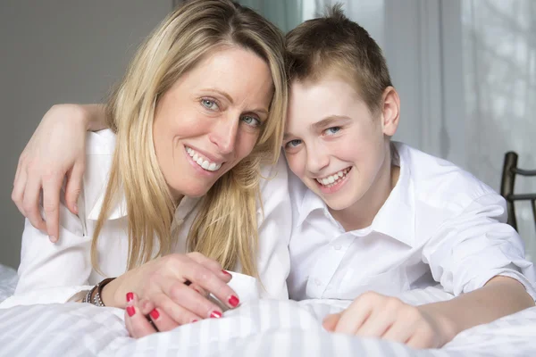 Madre e hijo relajándose juntos en la cama — Foto de Stock