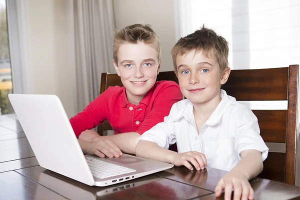 Счастливые дети мальчики смотрят на ноутбук в помещении — стоковое фото