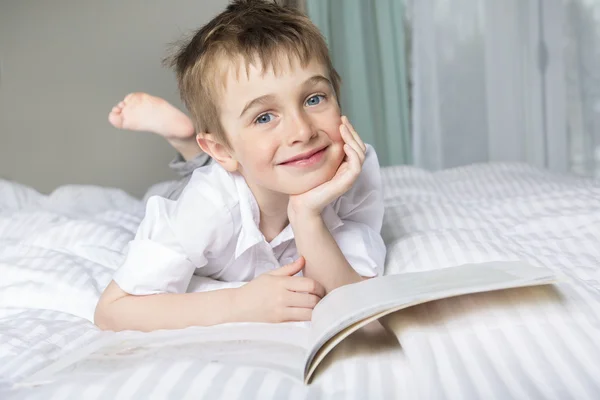 Маленький хлопчик читає перед сном у ліжку — стокове фото