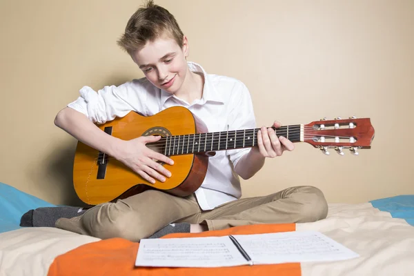 Adolescente tocando guitarra em seu quarto — Fotografia de Stock