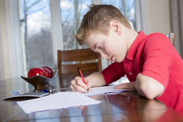 自宅で彼の宿題をやっている少年 — ストック写真