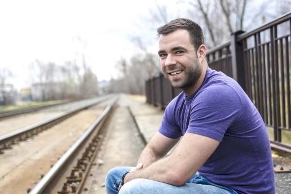 Портрет симпатичного молодого человека на железной дороге — стоковое фото