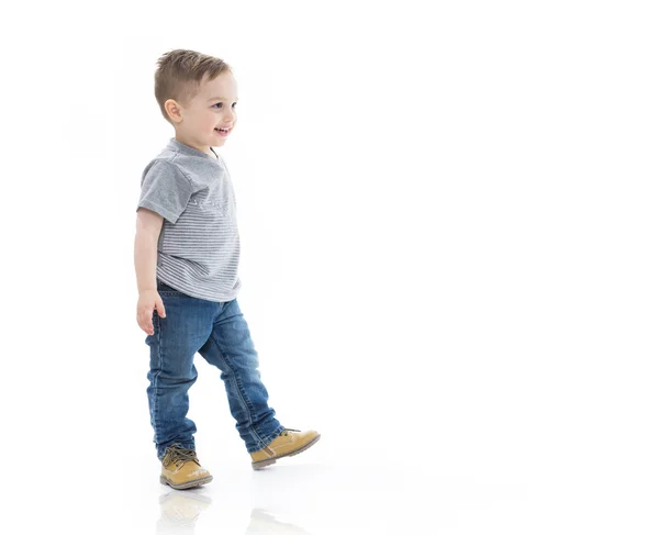 Drie jaar jongen eten en lopen geïsoleerd op wit — Stockfoto