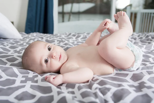 Förtjusande baby boy i sovrum. Nyfödda barnet avkopplande i sängen. — Stockfoto