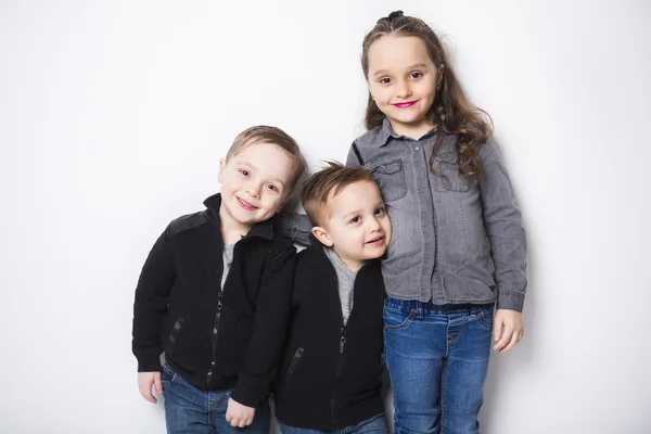 Little children standing together isolated on gray background — Stock Photo, Image