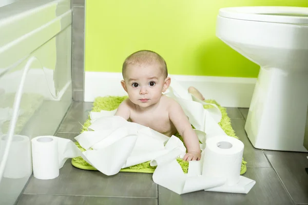 Tout-petit déchirant du papier toilette dans la salle de bain — Photo