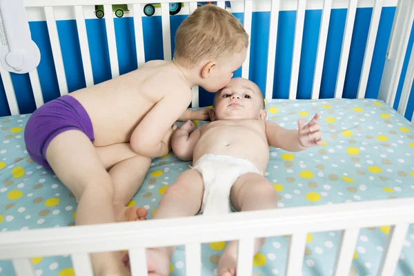 Lindo bebé en cuna con su hermano — Foto de Stock