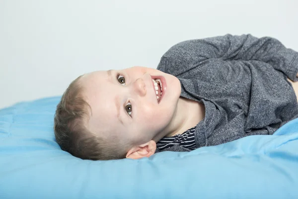 Gelukkige jongen tot op bed — Stockfoto